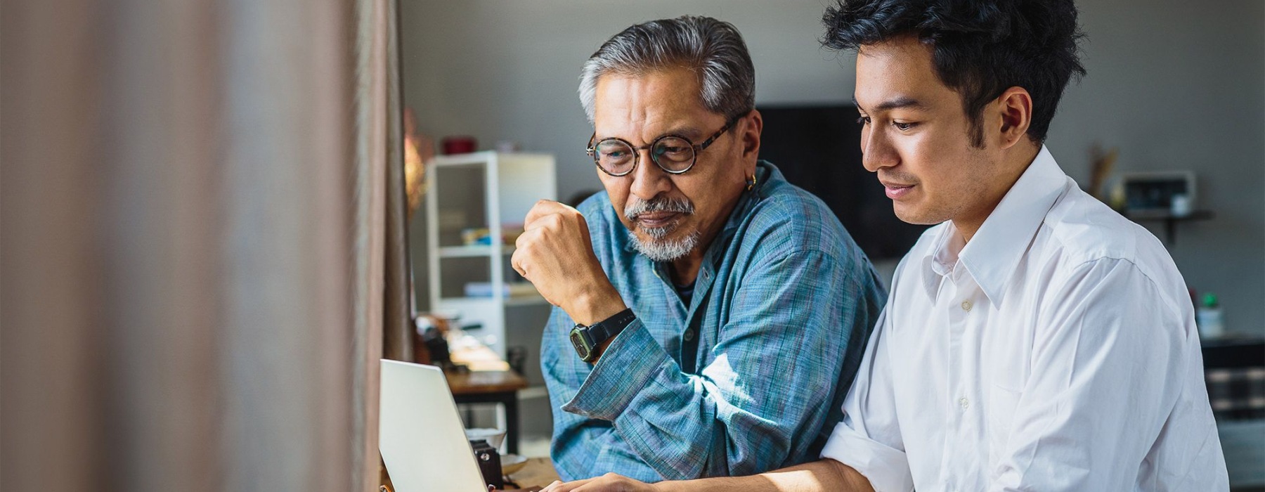a few men looking at a laptop